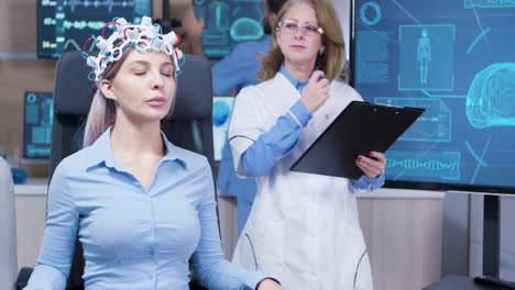 female sitting on a chair with brainwaves scaner headset