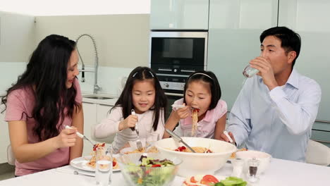 happy family having spaghetti dinner together