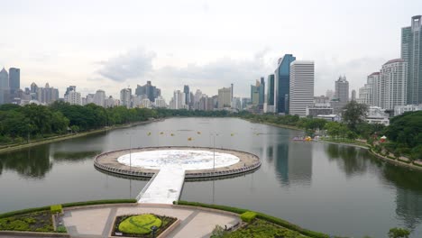 wide view of benjakiti park in bangkok with lake and city skyline