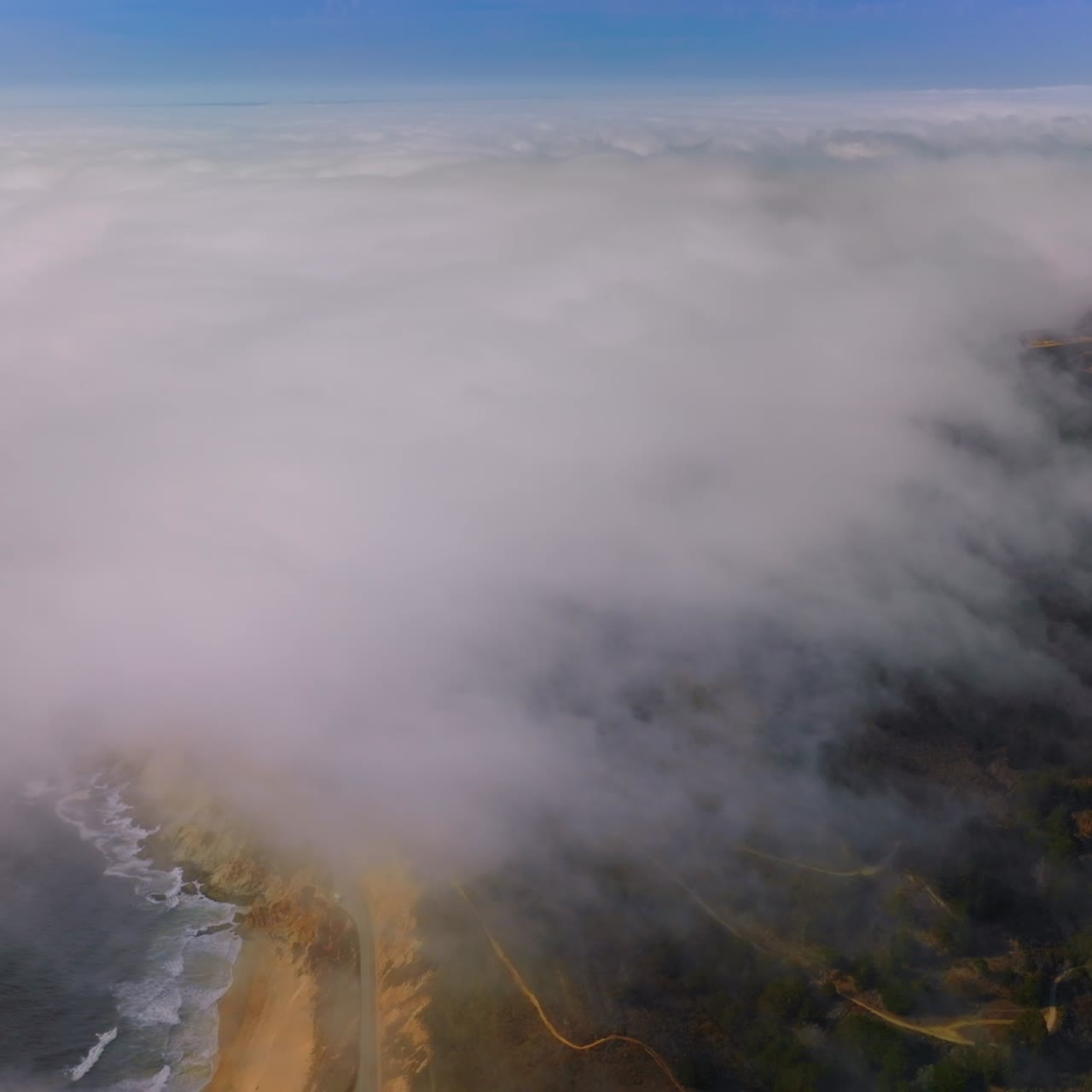 Pacific coastline covered with thick white fog. Rocky beach of Montara, California, USA. Aerial view