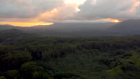 sobrevuelo aéreo cinematográfico que revela una exuberante selva tropical, ríos y montañas verdes con nubes al atardecer