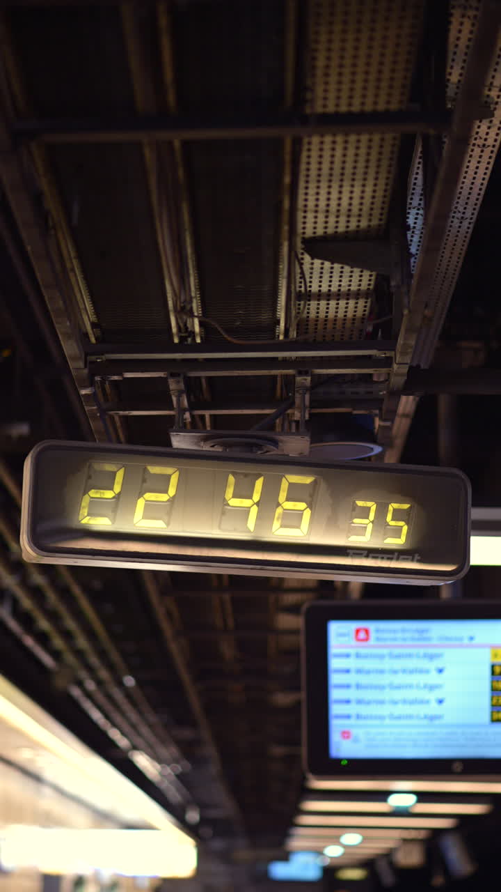 Digital clock showcasing the time at a train station. Vertical
