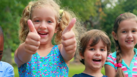 niños felices mirando a la cámara con los pulgares hacia arriba