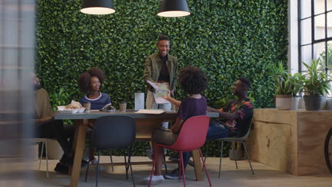 young black business people meeting team leader woman sharing corporate documents colleagues working together on creative project brainstorming ideas in trendy office