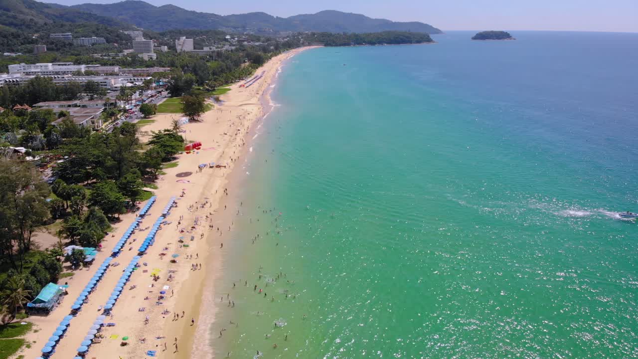 Vista aérea en picado de personas disfrutando nadando y relajándose en la playa en Phuket, Tailandia.
