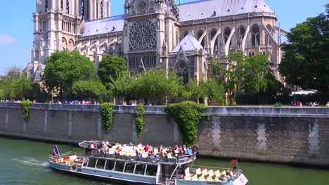 a riverboat travels on the seine near the notre dame cathedral in paris 2