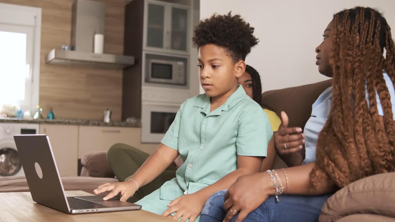 African American family using laptop together at home