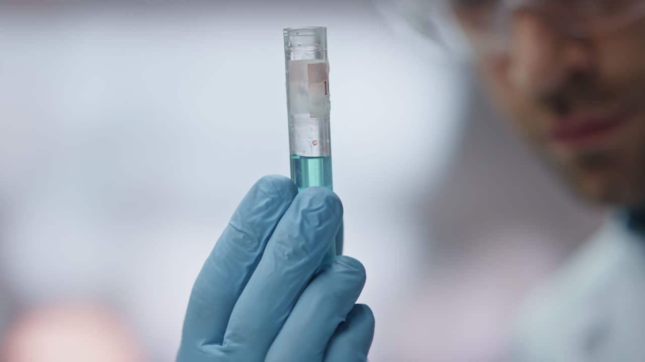 investigador de biotecnología mirando de cerca el tubo de ensayo con medicamentos de innovación.