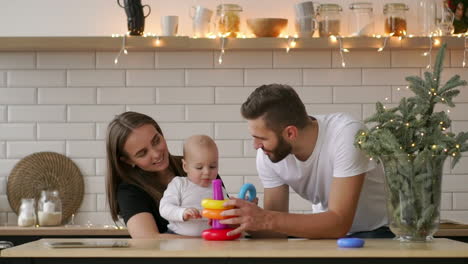 padres con un bebé jugando con un juego de madera