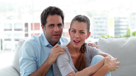 couple turning on something scary on the tv