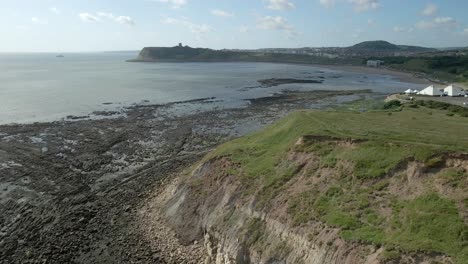 Vista-Aérea-Ascendente-De-La-Bahía-Norte,-Scarborough,-Yorkshire-Del-Norte-Con-Acantilados,-Costa,-Océano-Y-Castillo