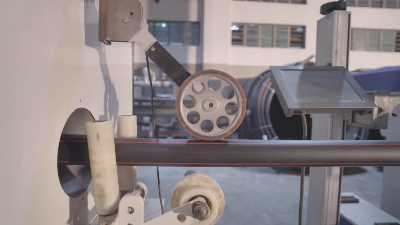 Robotic arm attaches a piece to a pvc pipe on a factory floor, showcasing modern automation technology in manufacturing