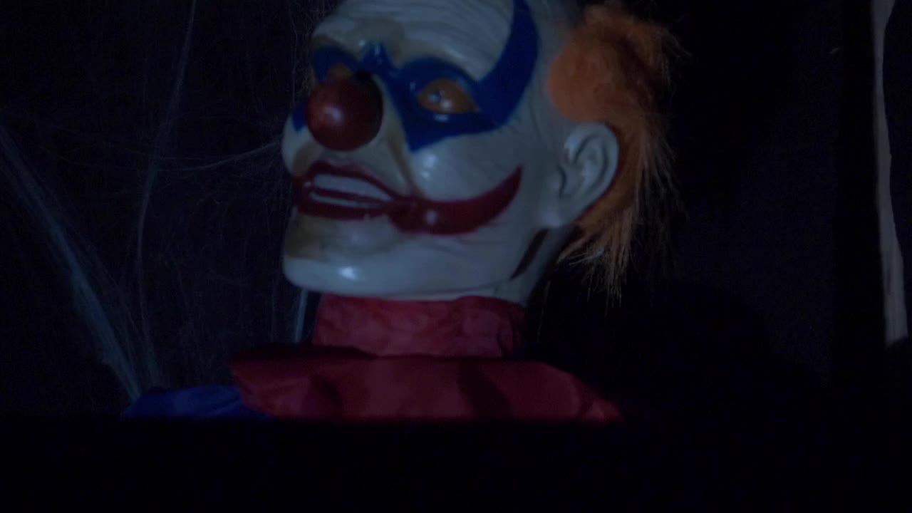 SLOW MOTION: Inside a creepy haunted house during Halloween with black lights and strobes, mannequins, skulls, clowns, evil rabbits, and spooky designs