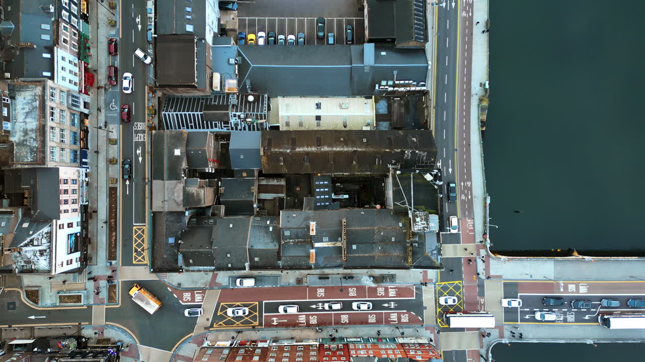 Aerial drone view of Cork's River Lee and its iconic bridges flowing through the city center, with dense architecture and traffic movement