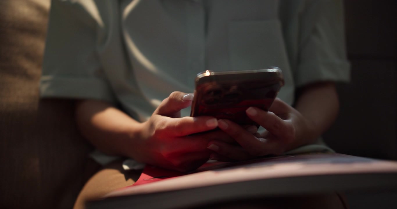 Una persona interagisce con il proprio smartphone in un ambiente interno accogliente.