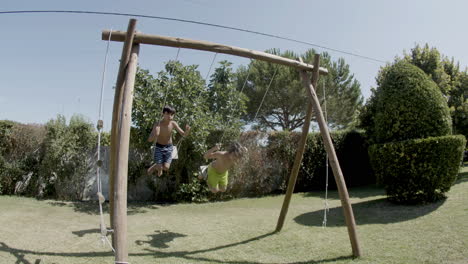 Boys-riding-on-swings-when-girls-running-up-shooting-water-guns.