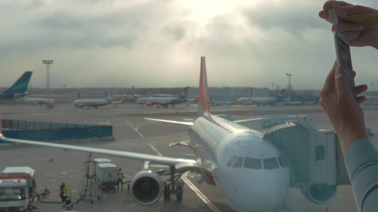 en el aeropuerto de domodedovo en moscú, una chica utiliza una terminal móvil en el teléfono y paga la compra de un boleto a través de una tarjeta.