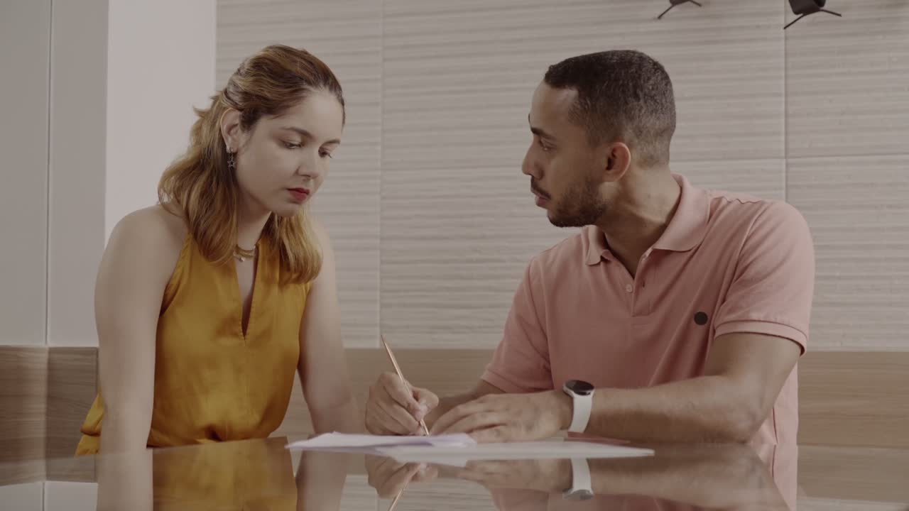 Two individuals engaged in a serious discussion over documents