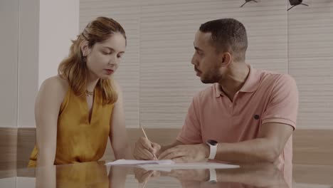 two individuals engaged in a serious discussion over documents
