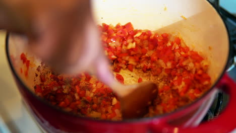 salteando pimientos rojos y cebollas en una olla para una receta de sopa especial - cámara lenta