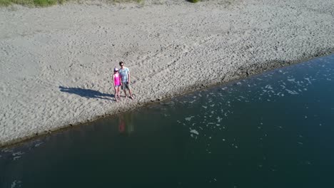 couple standing together on lakeshore 4k