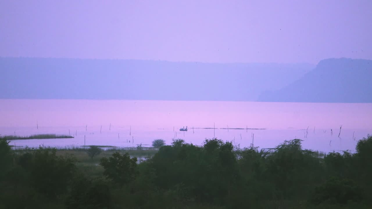 Distant fisherman boats doing fishing during the time of dawn in Tighra reservoir of Gwalior