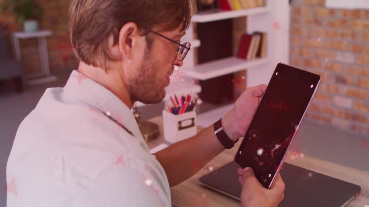 Holding tablet with glowing red lights, man working in home office desk