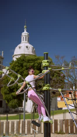 woman exercising on outdoor fitness equipment in a park