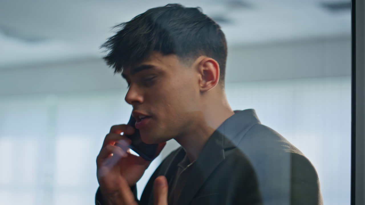 Angry boss arguing mobile phone gesturing expressively at glass office closeup