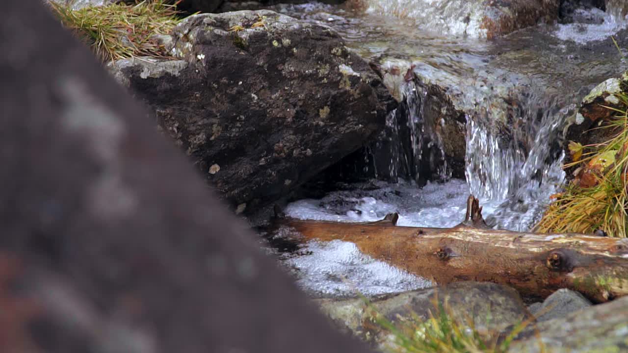 Truck-slide shot of splashing fresh mountain stream
