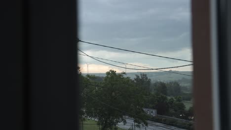 view through a window of several wind turbines moving under a storm. time lapse