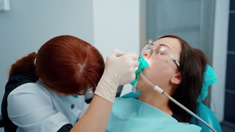 doctor stomatologist at work. female dentist in surgical uniform at the clinic while performing surgery for the patient