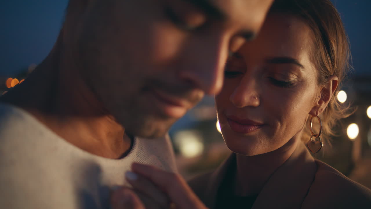 Closeup gentle partners embracing enjoying intimate moment on night street.