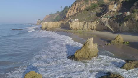 Tomas-Aéreas-De-La-Playa-El-Matador-Sobre-Olas-Y-Rocas-En-Una-Brumosa-Mañana-De-Verano-En-Malibu,-California