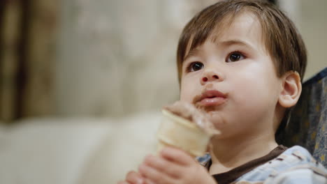 Portrait-of-a-two-year-old-baby,-eating-chocolate-ice-cream