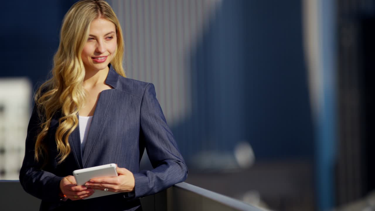Donna d'affari caucasica che usa la tecnologia tablet sul tetto in città