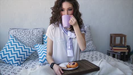 mujer disfrutando del desayuno en la cama