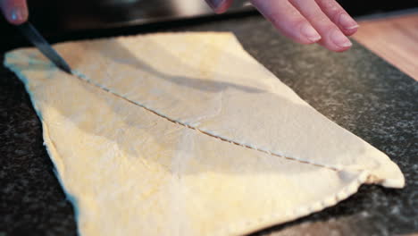 Female-hands-cutting-pre-made-pastry-into-triangles-for-baking