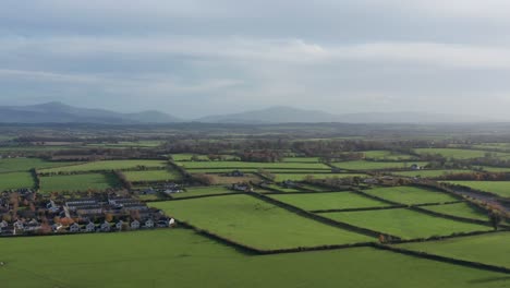 an aerial tracking shot of lush green rolling hills in the ireland countryside