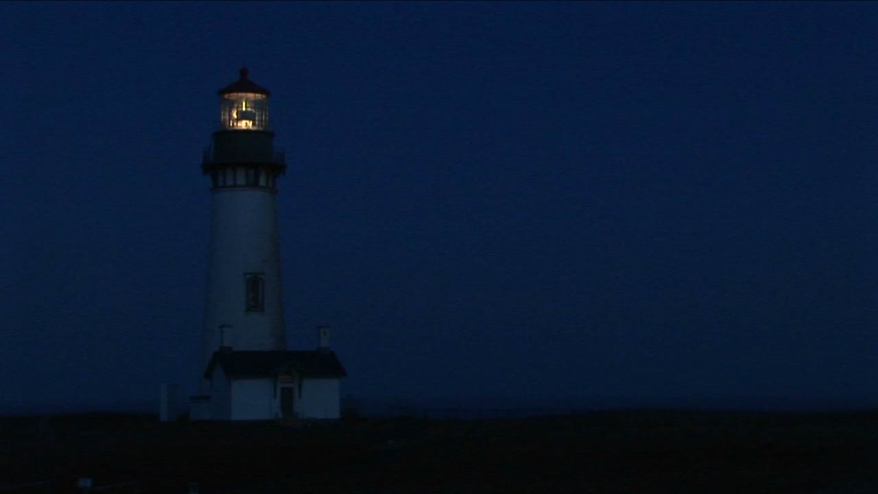 밝은 비콘이 지나가는 배에 대한 경고 신호로 밤에 등대의 중간 샷