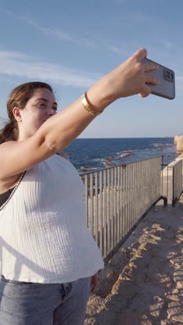 young woman taking a selfie by the mediterranean sea, acre old city.
