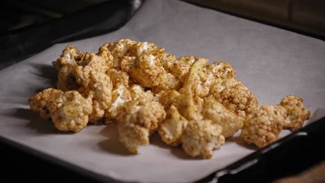 Person-Spreading-Seasoned-Raw-Cauliflower-onto-Baking-Sheet---Steady-Shot