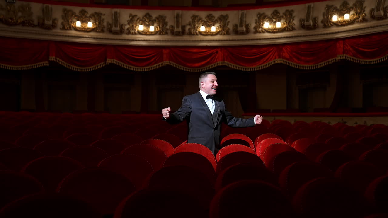 Comedian speaking in dark theater without people. Mad actor shouting in empty theatrical hall and calls someone. Consequences of pandemic.