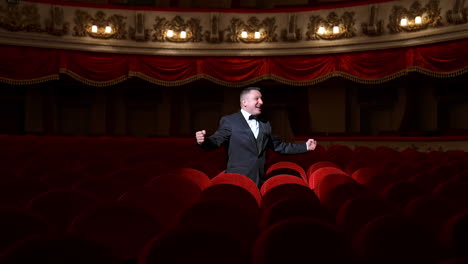 comedian speaking in dark theater without people. mad actor shouting in empty theatrical hall and calls someone. consequences of pandemic.
