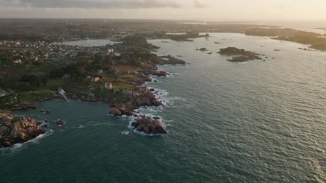 wide fly-away shot of phare du mean ruz lighthouse in bretagne france during sunset