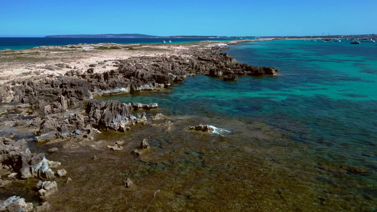 Punta des Borronar beach on Formentera Ibiza island with yachts mooring in clear turquoise water. Best aerial view flight overflight flyover drone