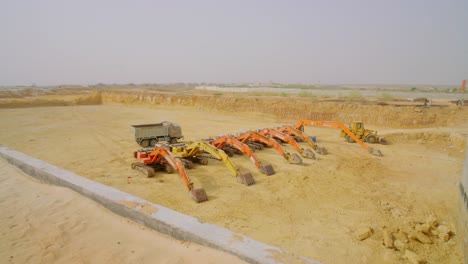 construction site featuring excavators and heavy machinery on sandy terrain