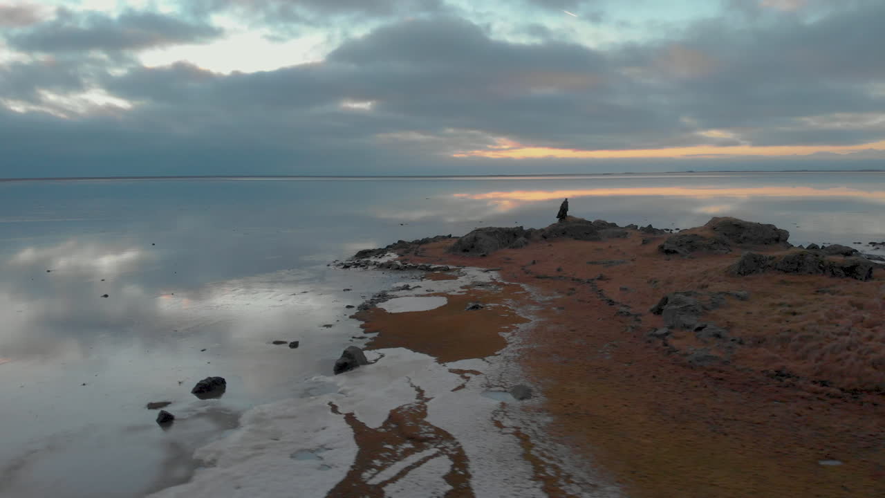 pareja caminando hasta el final de la costa de stokksnes, admirando la pacífica vista al océano islandés helado