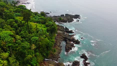 Vista-Aérea-De-Prósperos-árboles-Naturales-De-La-Selva-Cerca-De-La-Costa-Rocosa-Del-Pacífico-En-América-Del-Sur-Con-Agua-Limpia-Del-Océano-Azul