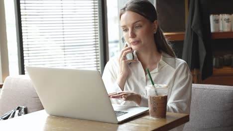 mujer trabajando en una computadora portátil en un café